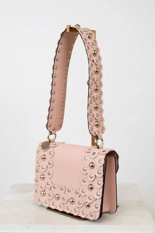Pink handbag with studded details on a white background