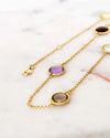 Gold necklaces with gemstones on a marble surface