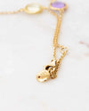 Gold necklace with pendants on a light background