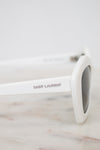 White Saint Laurent sunglasses on a marble surface