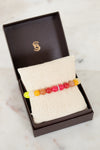 Colorful beaded bracelet in a brown box on a marble surface