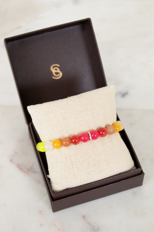 Colorful beaded bracelet in a brown box on a marble surface