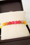 Colorful beaded bracelet on a white fabric surface