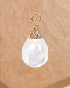 Moon Stone pendant with gold and silver accents on a beige background