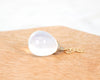 Moon Stone pendant with gold chain on a wooden surface