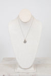 Necklace with a pendant on a mannequin bust against a white background