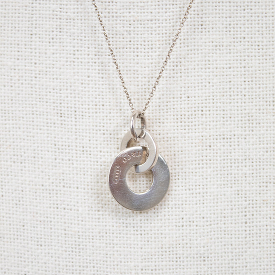 Silver necklace with a unique pendant on a light gray background
