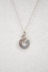 Silver necklace with a unique pendant on a light gray background