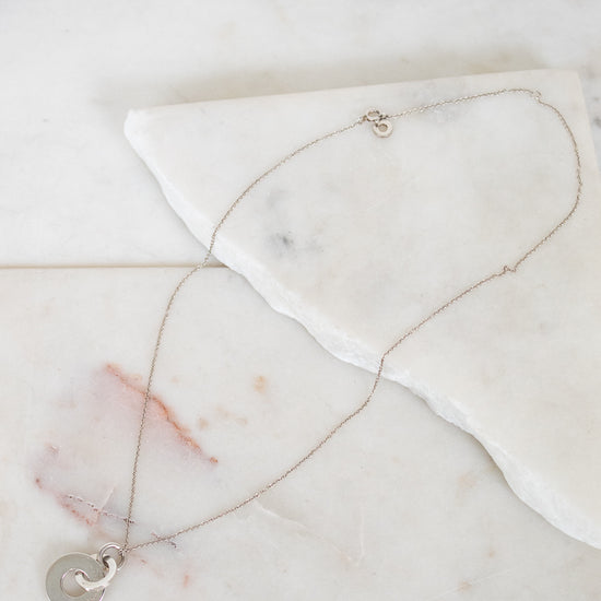 Necklace with a interlocking circles pendant on a marble surface