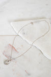 Necklace with a interlocking circles pendant on a marble surface