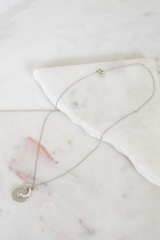 Necklace with a interlocking circles pendant on a marble surface