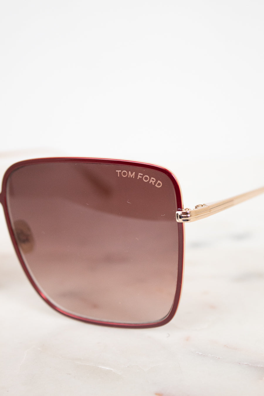 Tom Ford sunglasses with a brown gradient lens on a white background