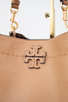 Close-up of a brown leather handbag with gold hardware and a visible brand logo.