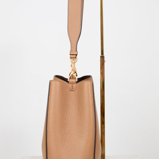 Tan handbag with a strap on a white background
