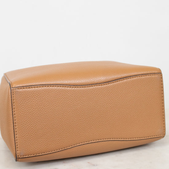 Tan leather handbag on a light marble surface