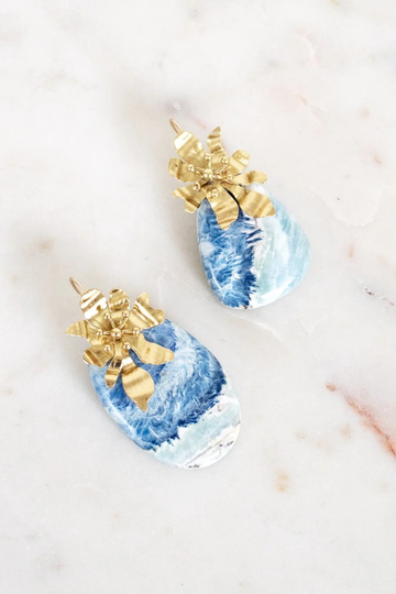 Blue and gold earrings on a light background