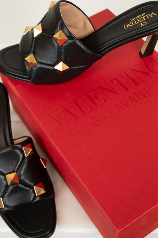 Black sandals with gold studs on a red Valentino box