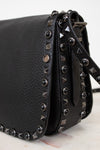 Black leather handbag with studded details on a white background