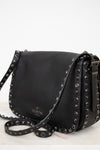 Black leather handbag with studded details on a white background