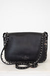 Black leather handbag with studs on a white background
