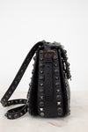 Black studded handbag on a white background