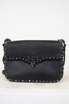 Black leather purse with gunmetal hardware on white background