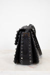 Black studded handbag on a white background