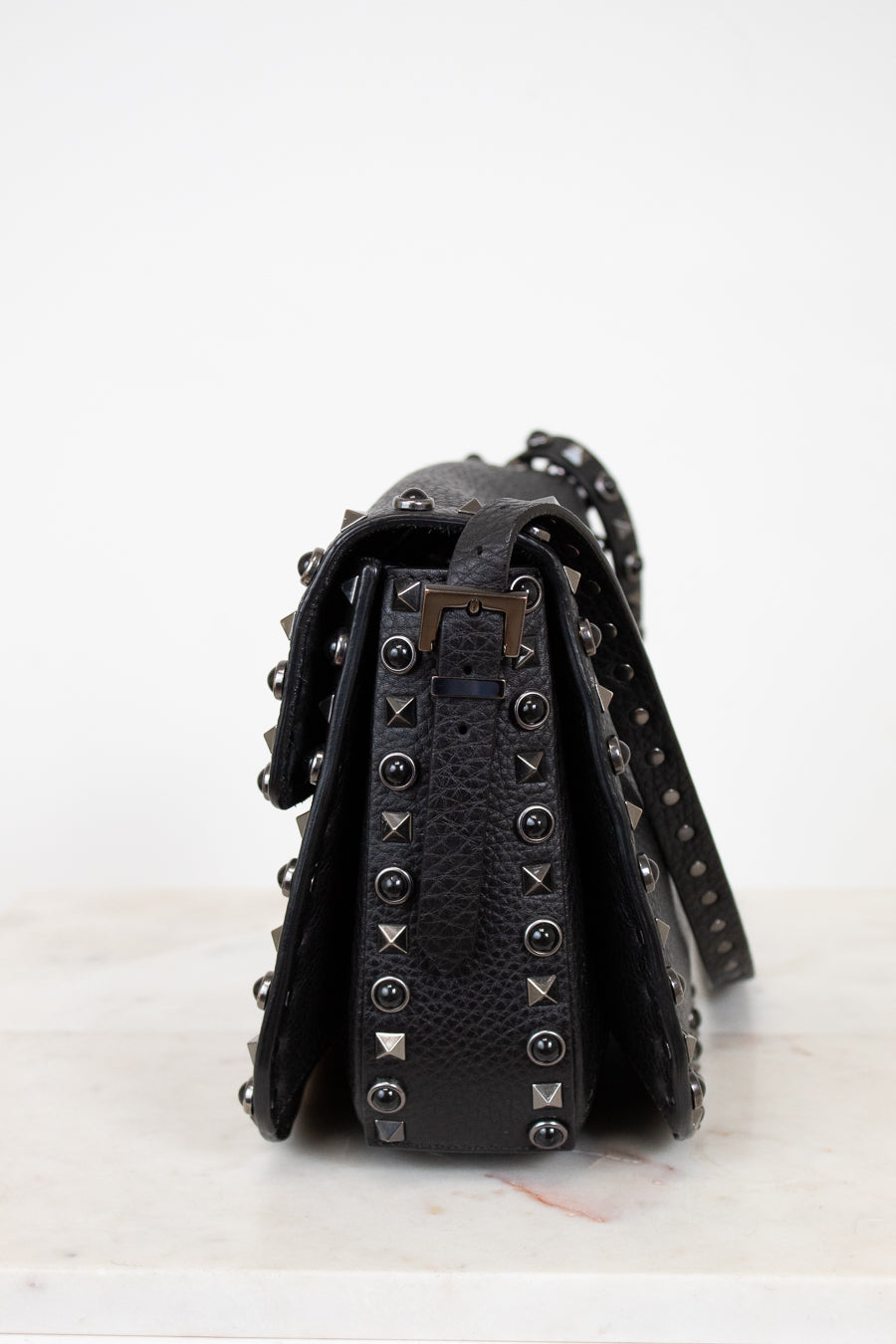 Black studded handbag on a white background