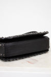 Black studded handbag on a white surface