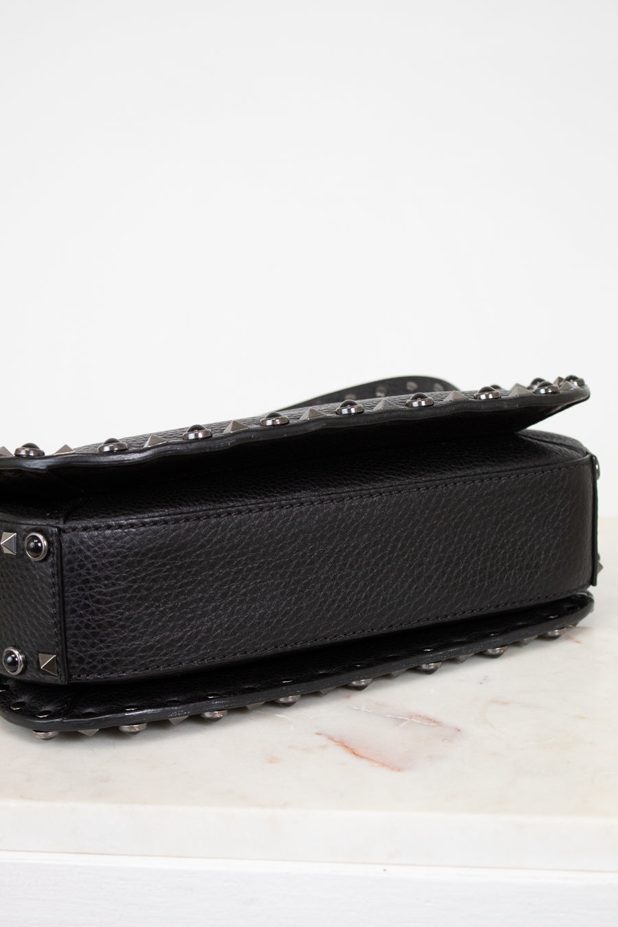Black studded handbag on a white surface