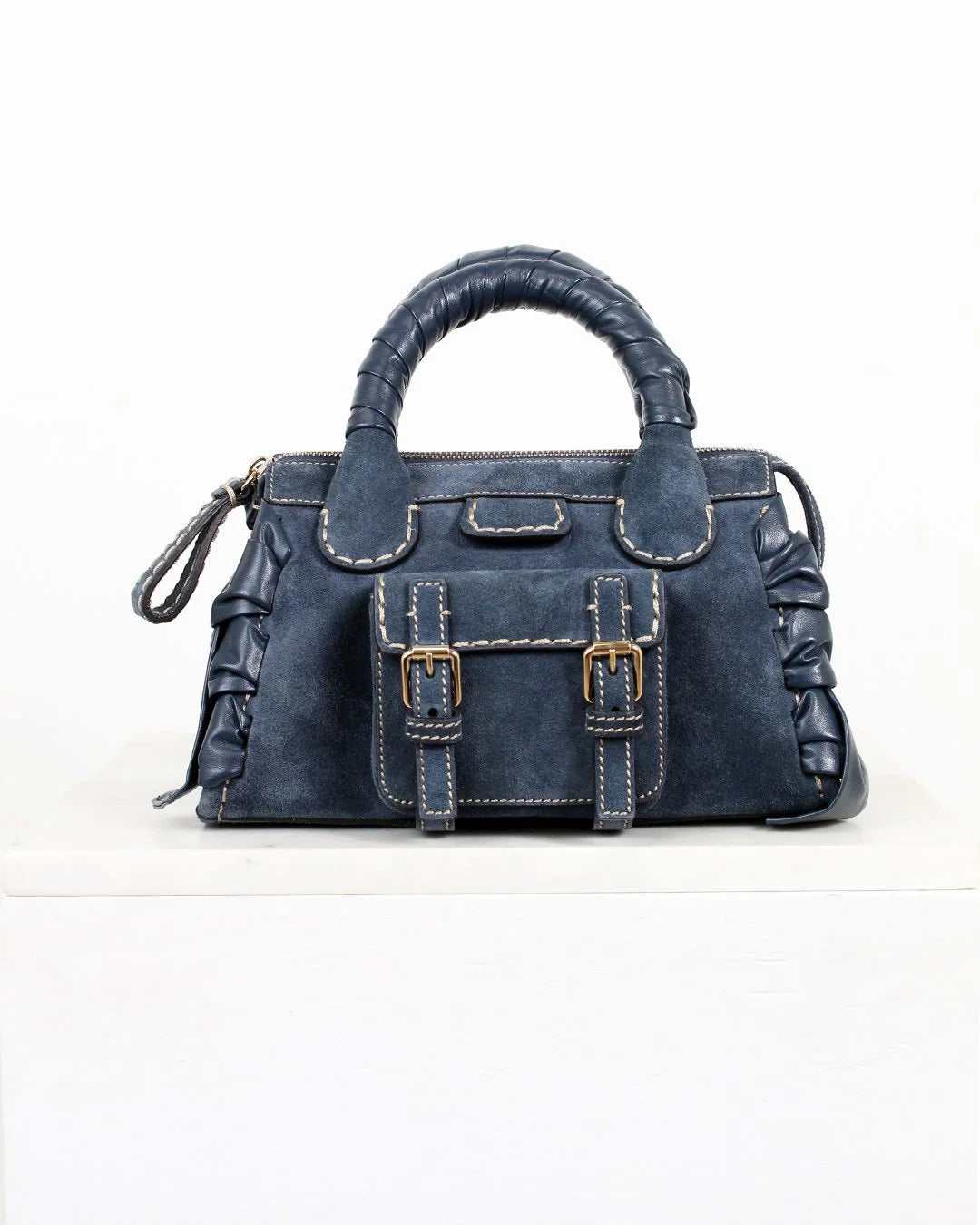 Blue handbag with a buckle detail on a white background