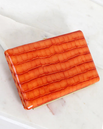 Orange textured clutch bag on a light background