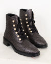 Pair of black and silver textured boots with pearl embellishments on a light background