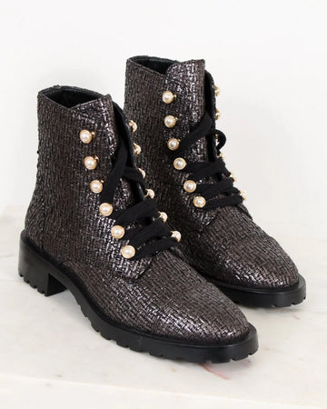 Pair of black and silver textured boots with pearl embellishments on a light background