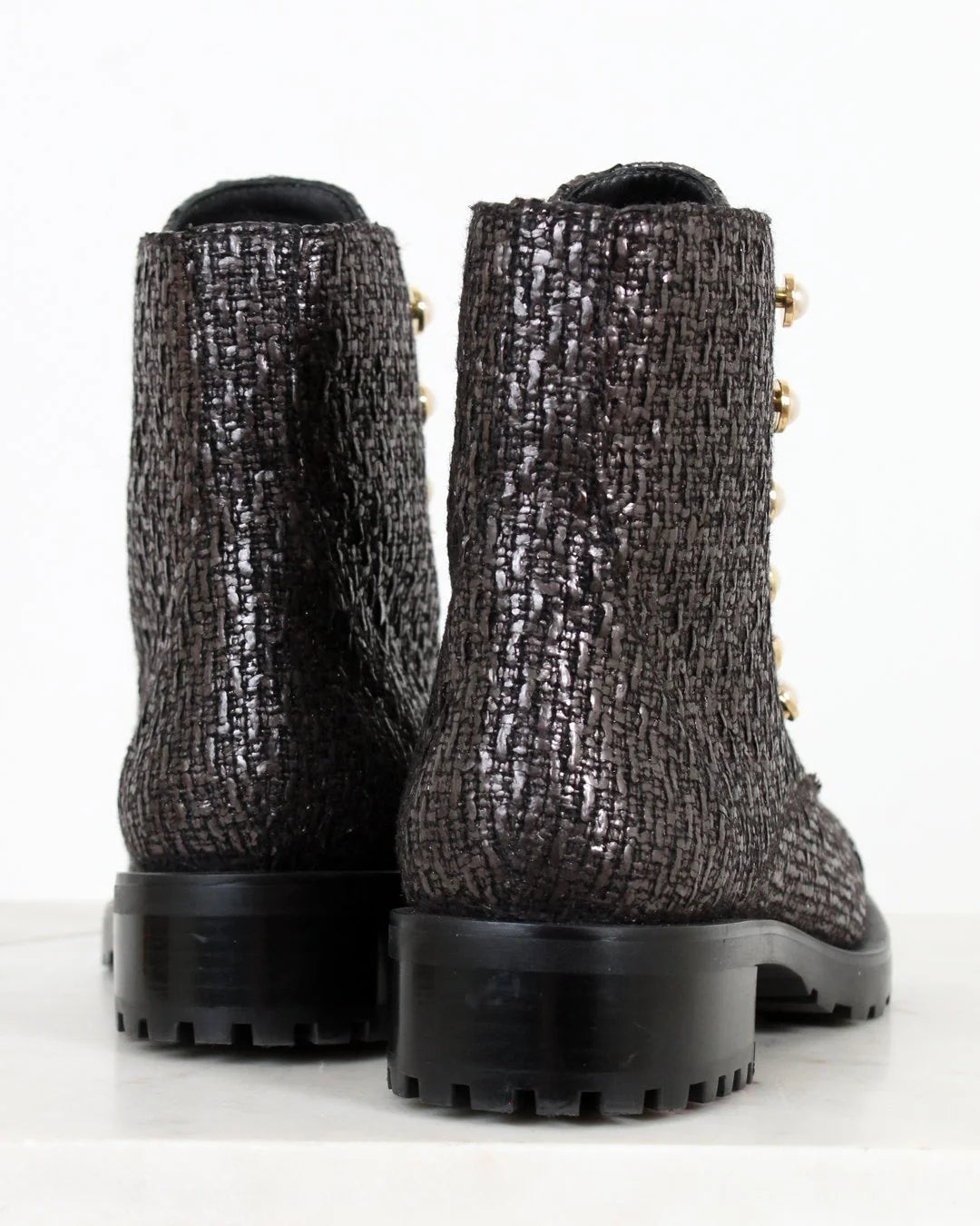 Pair of black and silver tweed boots on a white background