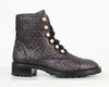 Metallic textured boot with pearl buttons on a white background