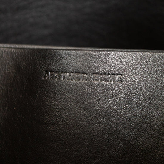 Close-up of a dark brown leather purse with branding.