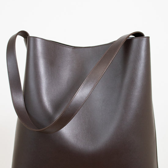 Brown leather tote bag on a white background