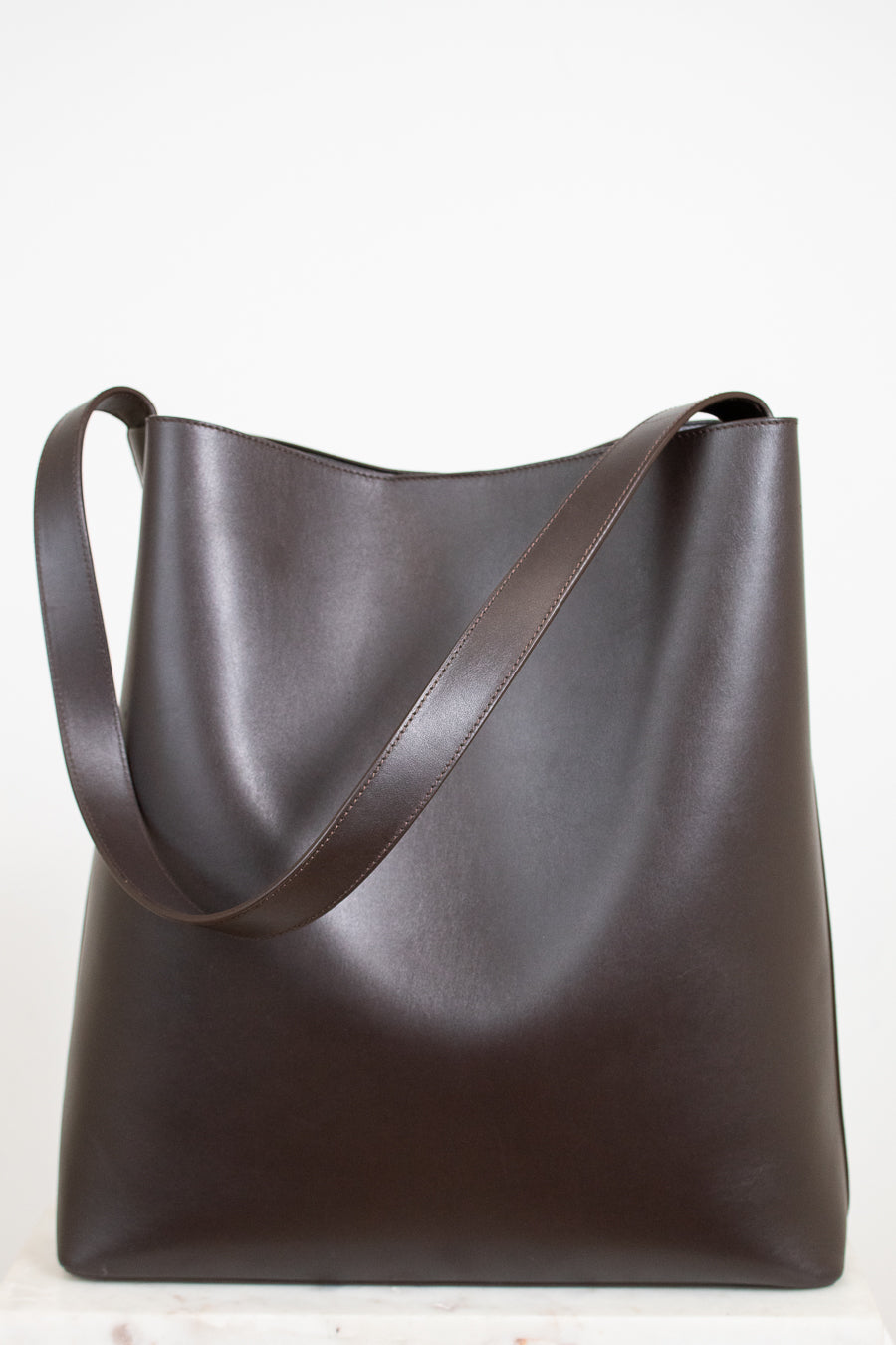 Brown leather tote bag on a white background
