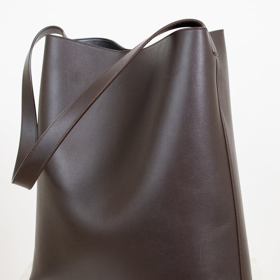 Brown leather tote bag on a white background