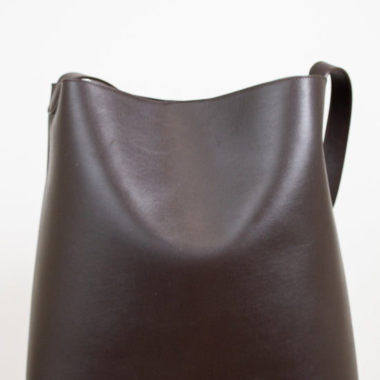 Brown leather shoulder bag on a white background