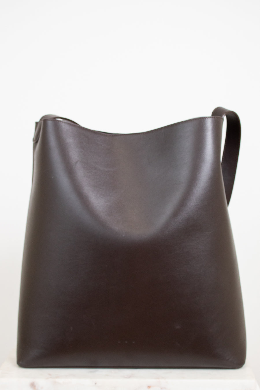 Brown leather shoulder bag on a white background