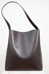 Dark brown leather handbag with a shoulder strap on a white background