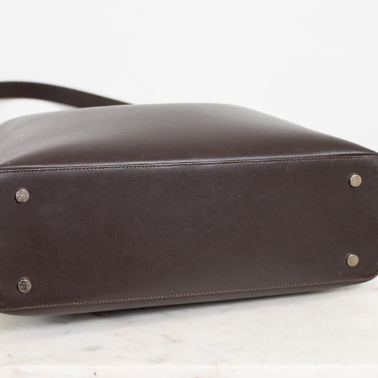 Brown leather handbag with silver studs on a white background