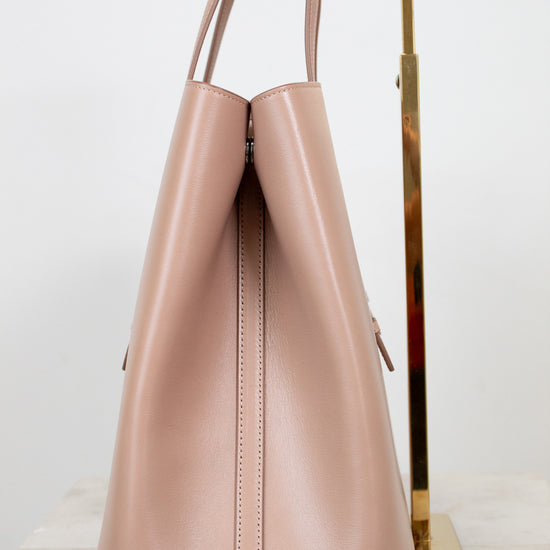 Side angle of beige leather tote on white background