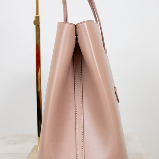Side angle of beige leather tote on white background
