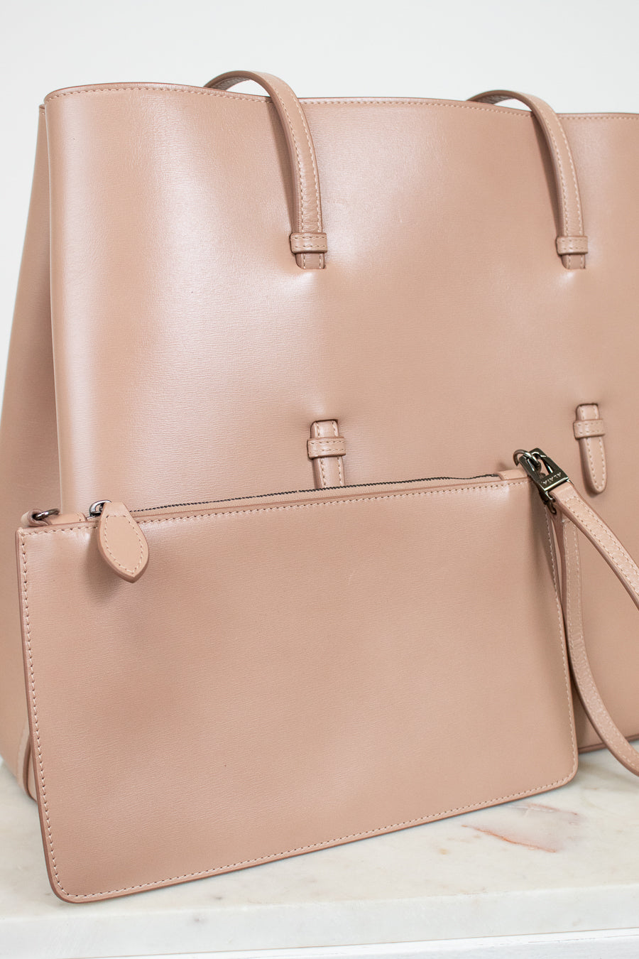 Smooth beige leather tote and matching pouch on white background