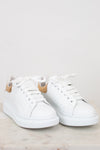White sneakers with tan accents on a light gray background