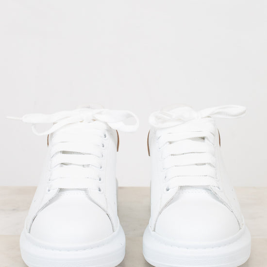 Pair of white sneakers on a light gray background