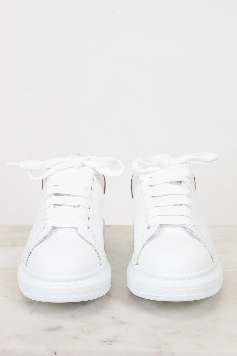 Pair of white sneakers on a light gray background